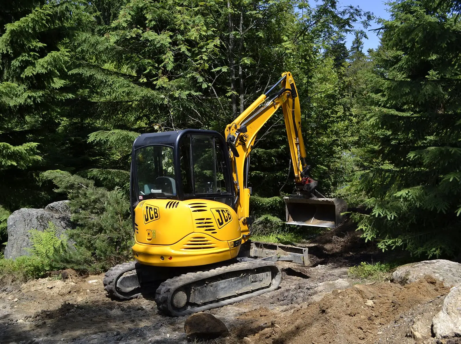 A compact excavator working in a garden
