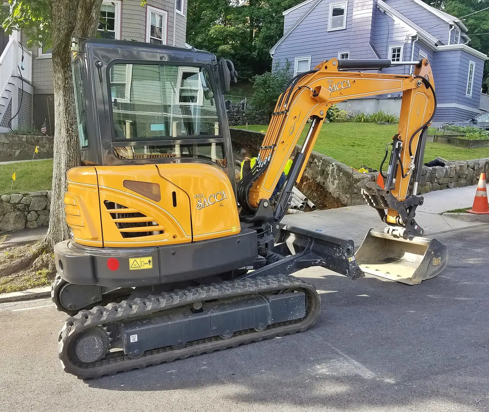 A compact excavator parked on a residential street
