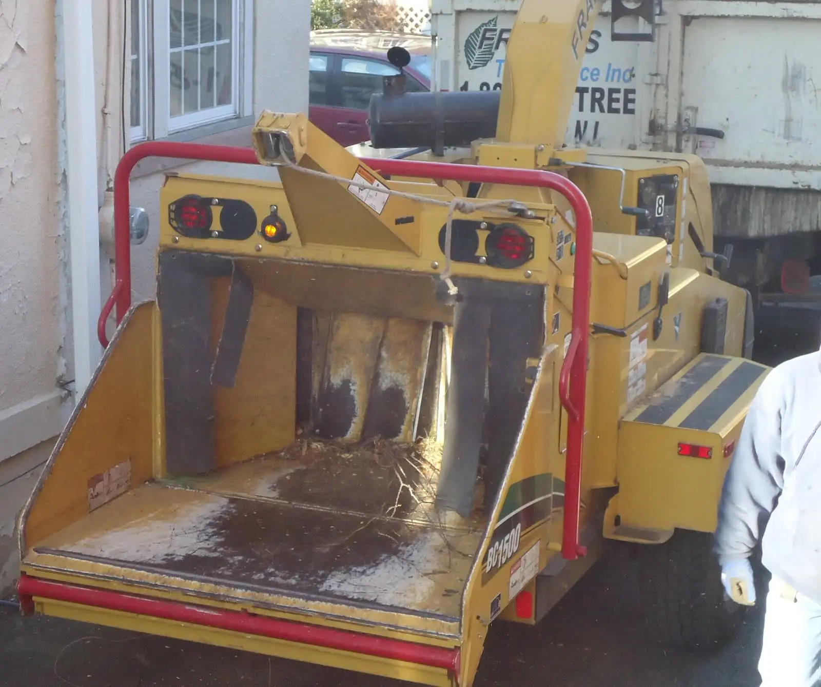 A wood chipper and truck parked outside a house