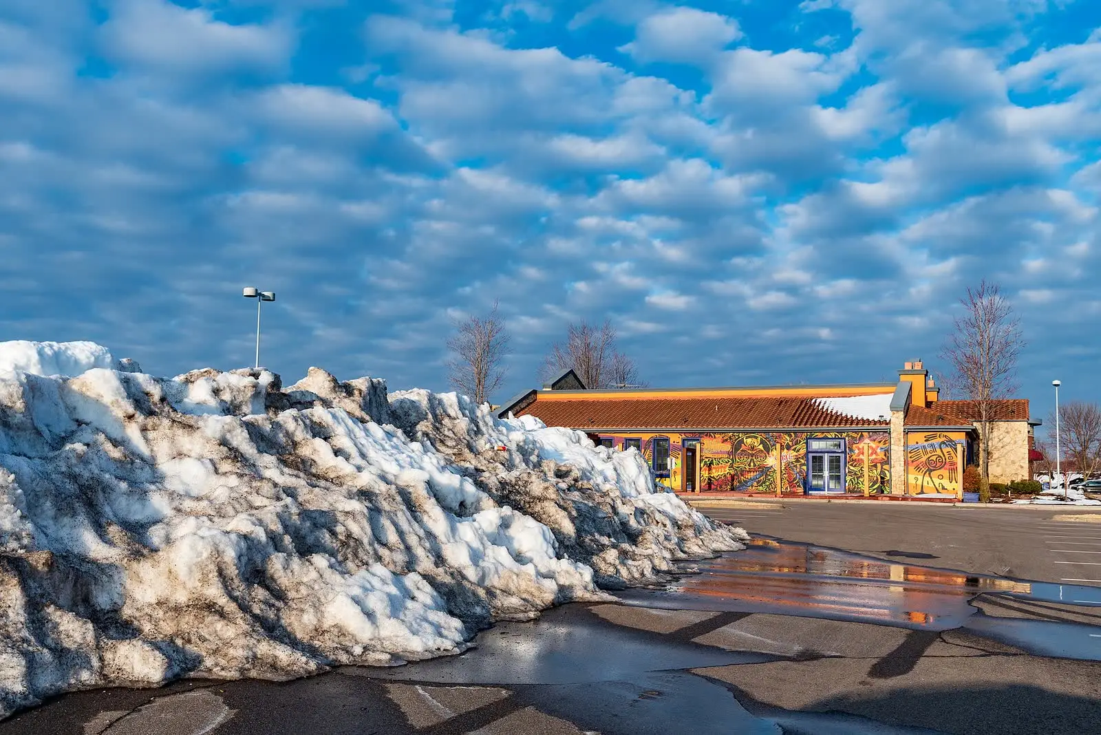 A pile of plowed snow in a parking lot