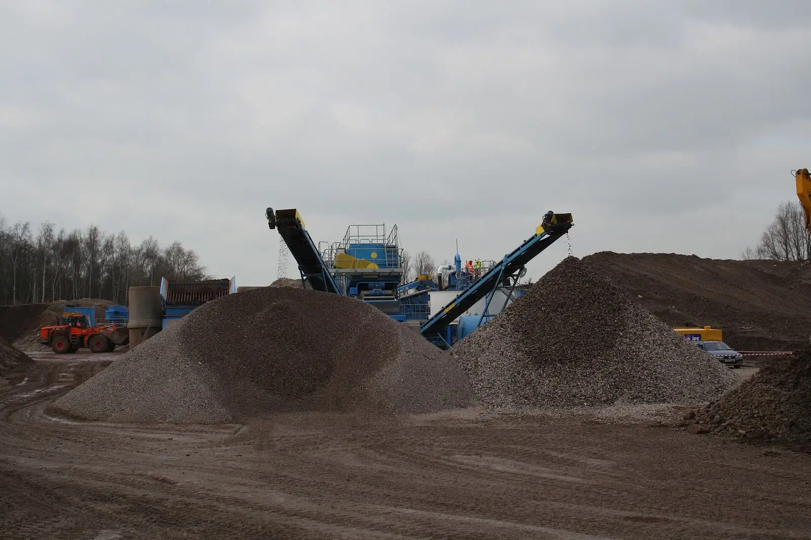 Stockpiles of crushed recycled aggregate beside mobile crushing and screening plant